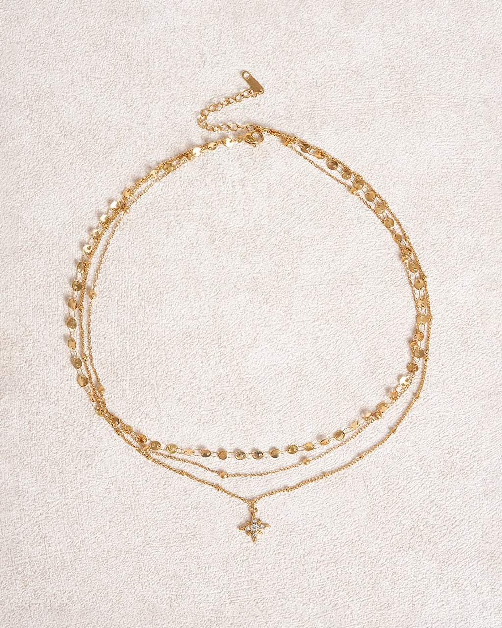Collana dorata con strass a stella a quattro punte