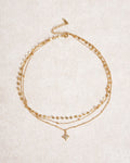 Collana dorata con strass a stella a quattro punte