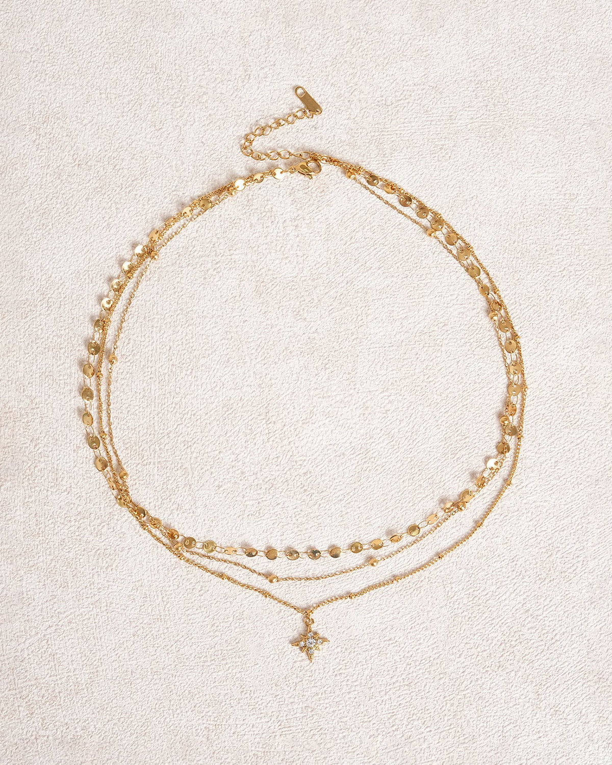 Collana dorata con strass a stella a quattro punte