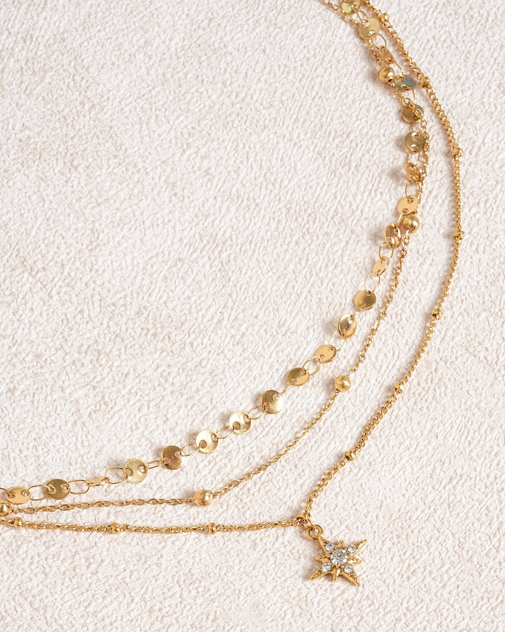Collana dorata con strass a stella a quattro punte